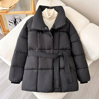 Model wearing a short tie-waist puffer jacket with a stand collar and boots