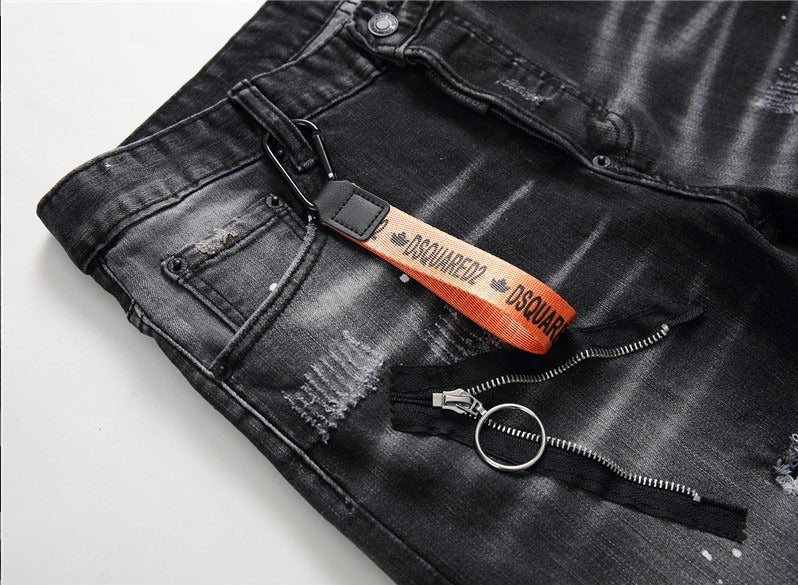 Men’s black and gray distressed jeans with torn holes and zipper decoration.

