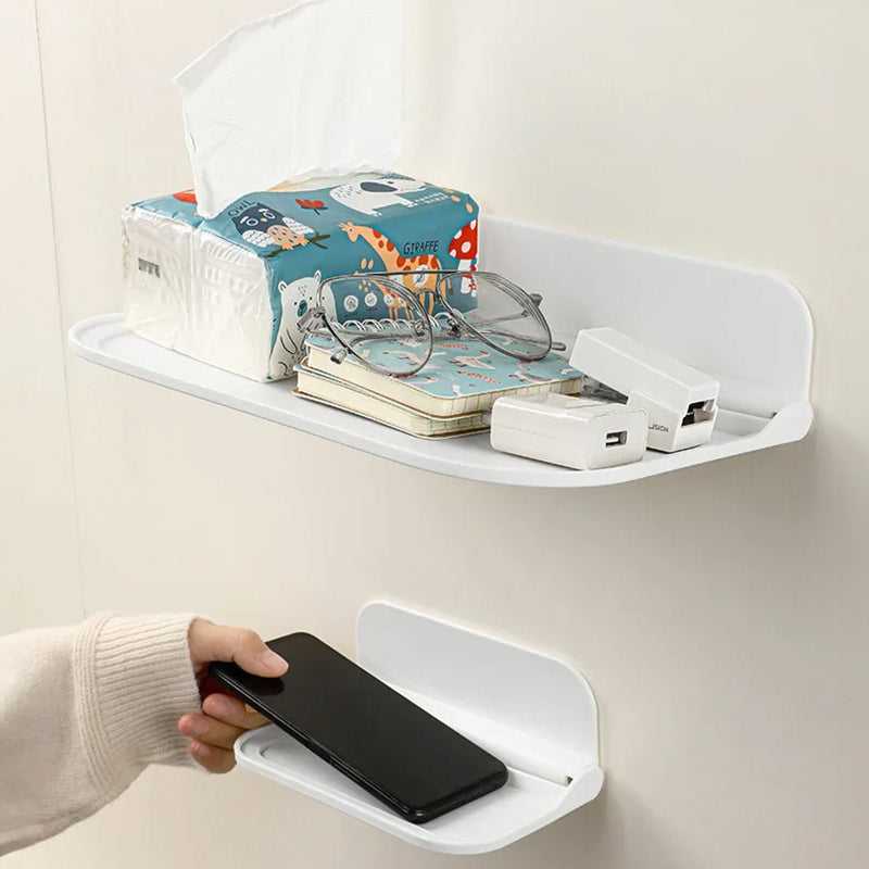 Wall-mounted plastic floating shelf in a modern bathroom holding towels