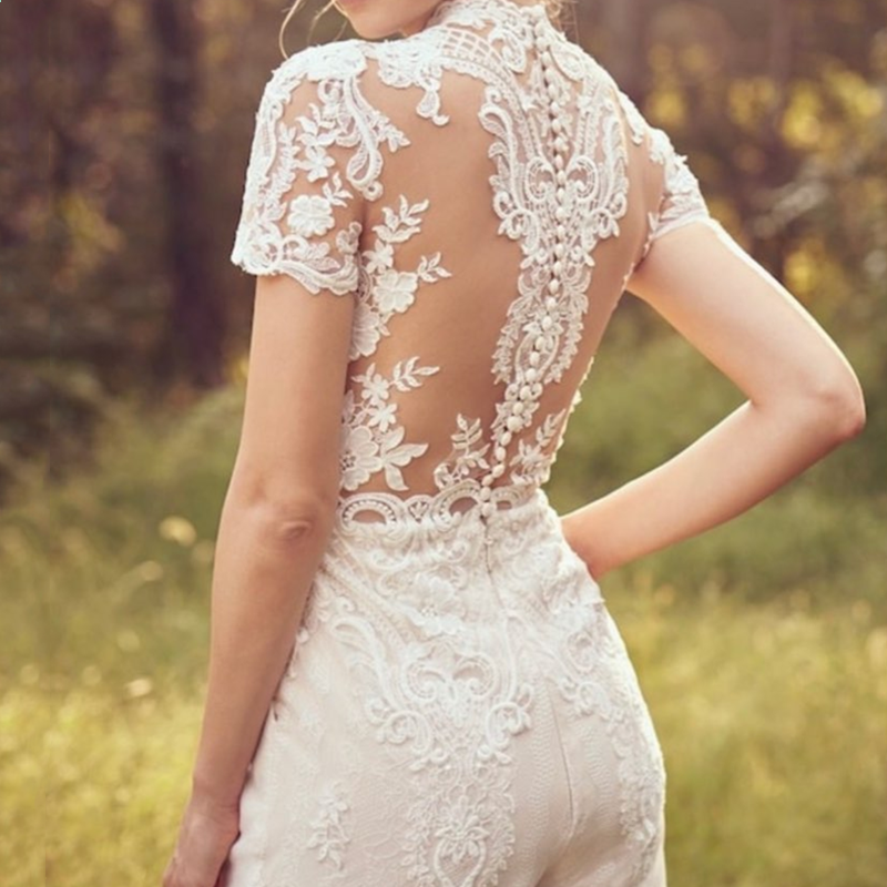 Modern bride pants suit featuring a short sleeve wedding jumpsuit, tailored for elegance and a sophisticated bridal look.


