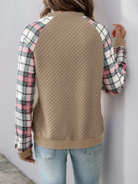 Front view of women’s plaid half zip sweatshirt with long sleeves and textured fabric


