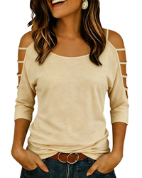 A woman wearing a beige cold-shoulder long-sleeve top with cutout details on the sleeves, paired with dark blue jeans and a brown belt with a silver buckle.