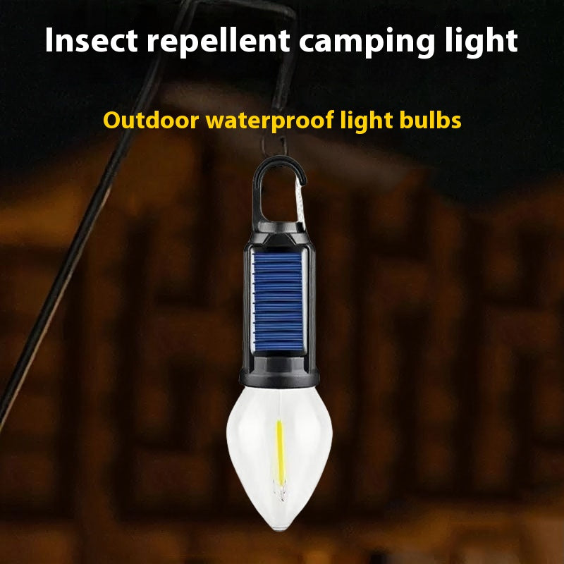 Solar-powered camping lantern with tungsten bulb hanging in a tent outdoors

