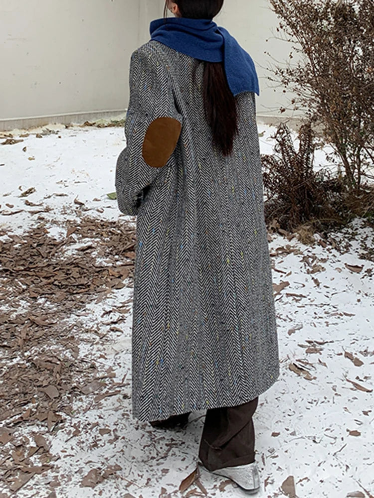 Model wearing a solid plaid minimalist woolen coat in a city street setting