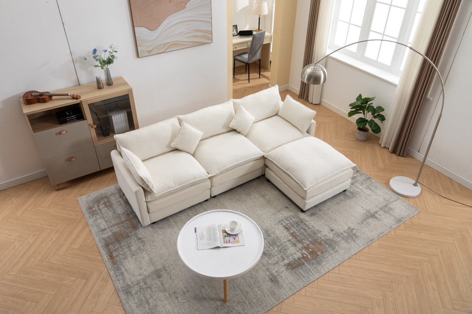 Modern L-shaped 3-seater modular sofa with ottoman in a living room setting.

