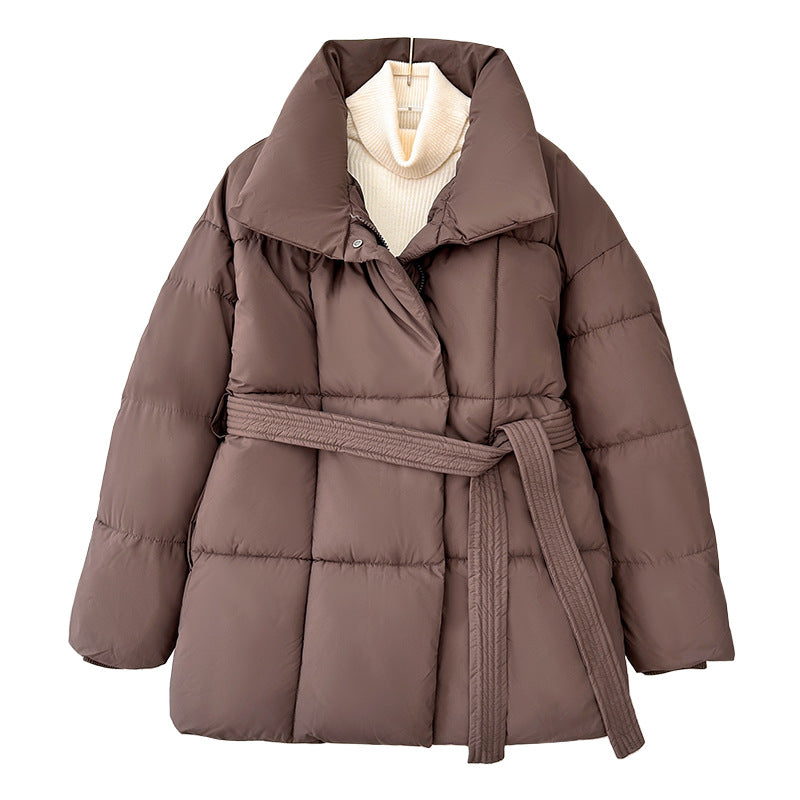 Model wearing a short tie-waist puffer jacket with a stand collar and boots