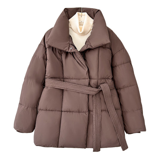 Model wearing a short tie-waist puffer jacket with a stand collar and boots