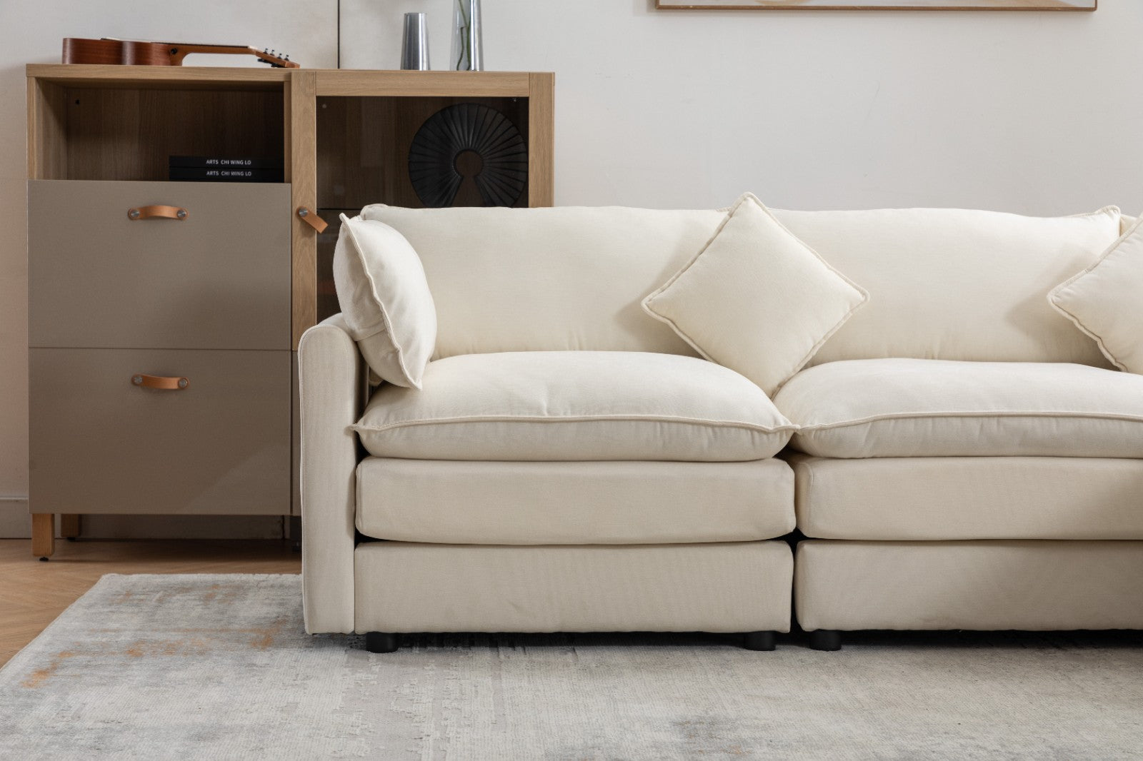 Modern L-shaped 3-seater modular sofa with ottoman in a living room setting.

