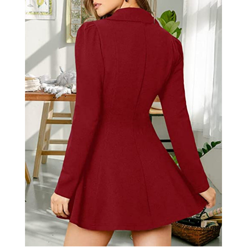 A woman wearing a long-sleeve red mini dress with a structured collar and flared skirt, shown from the back in a bright indoor room.