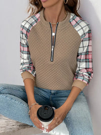 Front view of women’s plaid half zip sweatshirt with long sleeves and textured fabric


