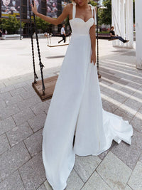A stylish sexy sling wedding dress featuring a sleek silhouette, delicate straps, and a flowy design, perfect for modern brides.

