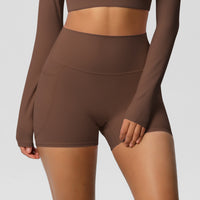 Brown athletic outfit with long sleeves and shorts on a plain background