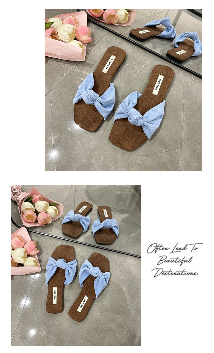 A collage showing the same pair of slide sandals in two settings on a tiled floor, each with a pair reflected in a mirror. The sandals have brown suede-like footbeds and light blue fabric bow straps.