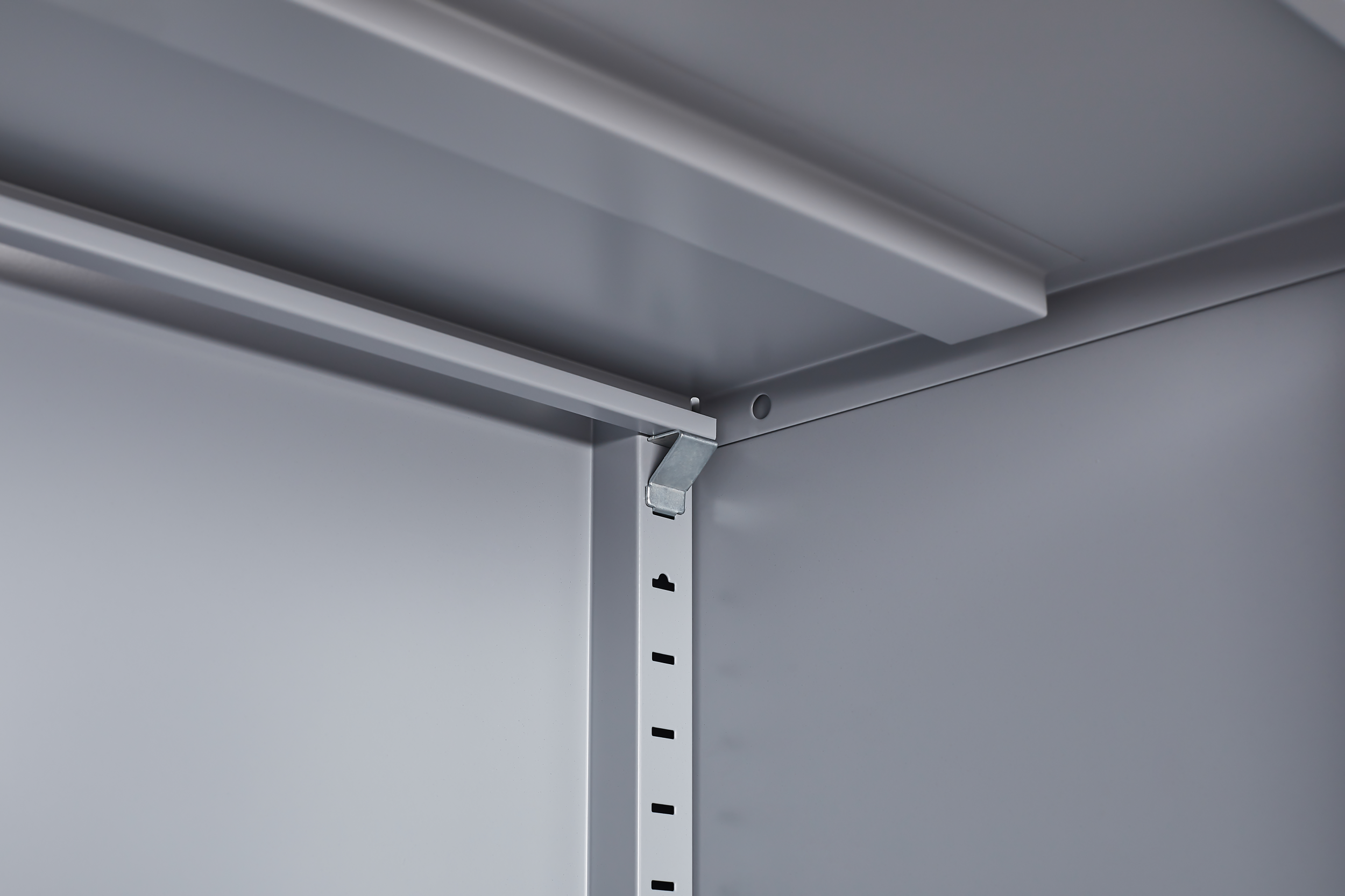 Grey metal kitchen storage cabinet with door and adjustable shelf in a modern kitchen