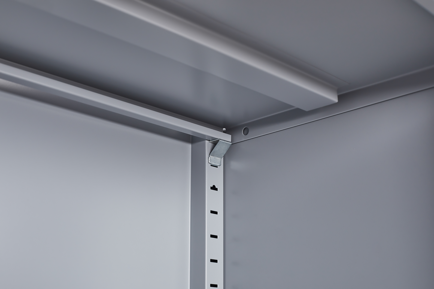 Grey metal kitchen storage cabinet with door and adjustable shelf in a modern kitchen