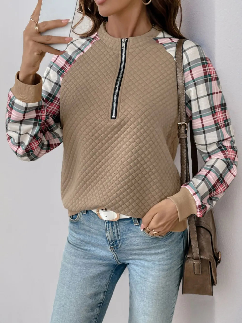 Front view of women’s plaid half zip sweatshirt with long sleeves and textured fabric

