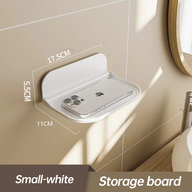 Wall-mounted plastic floating shelf in a modern bathroom holding towels