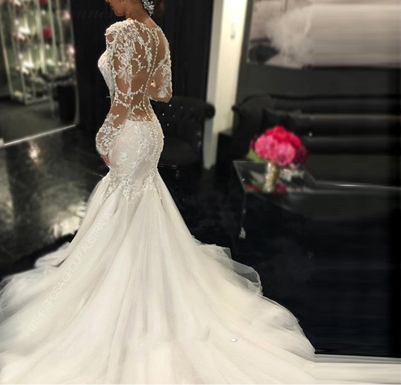 A trailing white lace wedding dress with a slim fit and elegant design, featuring intricate lace details for a timeless bridal look.

