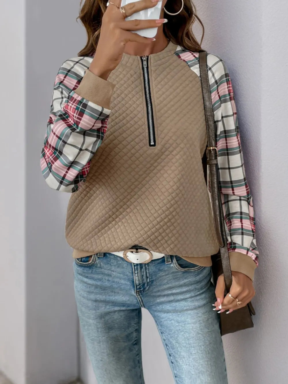 Front view of women’s plaid half zip sweatshirt with long sleeves and textured fabric

