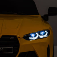 Yellow BMW M4 12V electric ride-on car for kids, featuring authentic design with working headlights, MP3 player, and forward/reverse motion. Comes with adjustable seat and steering wheel, providing a realistic driving experience for children aged 3-6