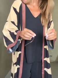 Model wearing printed long cardigan with jeans and boots

