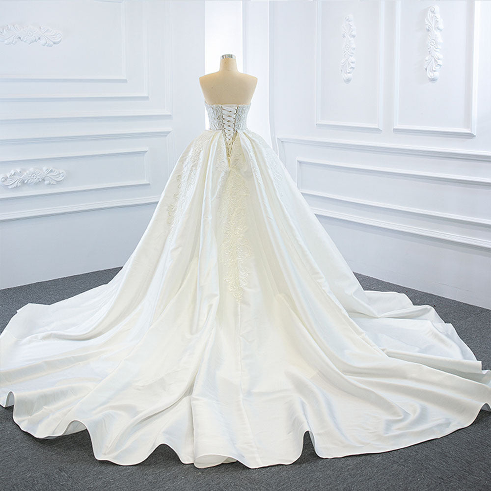 Elegant strapless tube top wedding dress with a fishtail silhouette, detachable flowing train, and intricate lace details for a dreamy bridal look.

