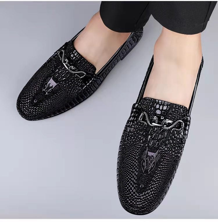 Men’s slip-on driving shoes in snake-pattern embossed leather with flat sole design.

