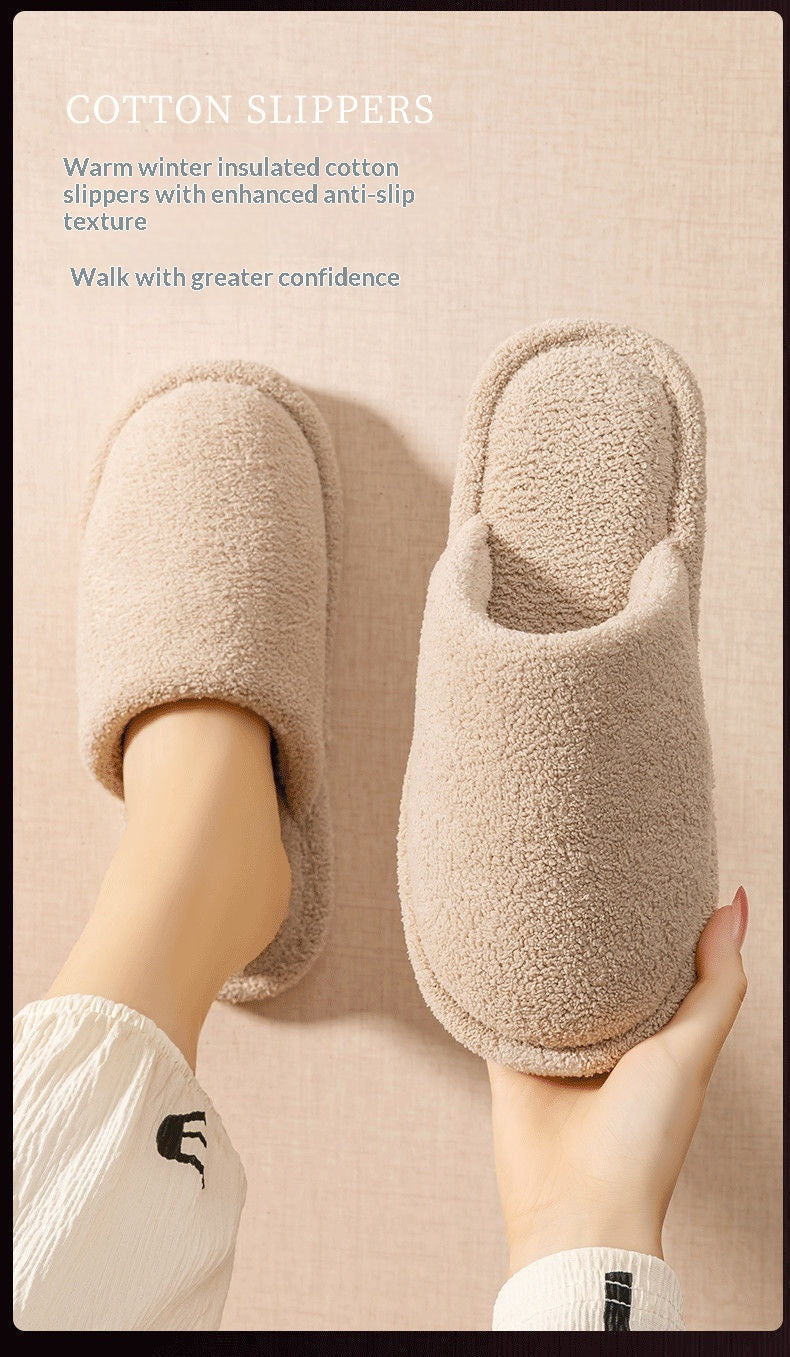A pair of beige plush cotton slipper slippers, with one being worn on a foot and the other held in a hand, set against a matching beige background with promotional text.
