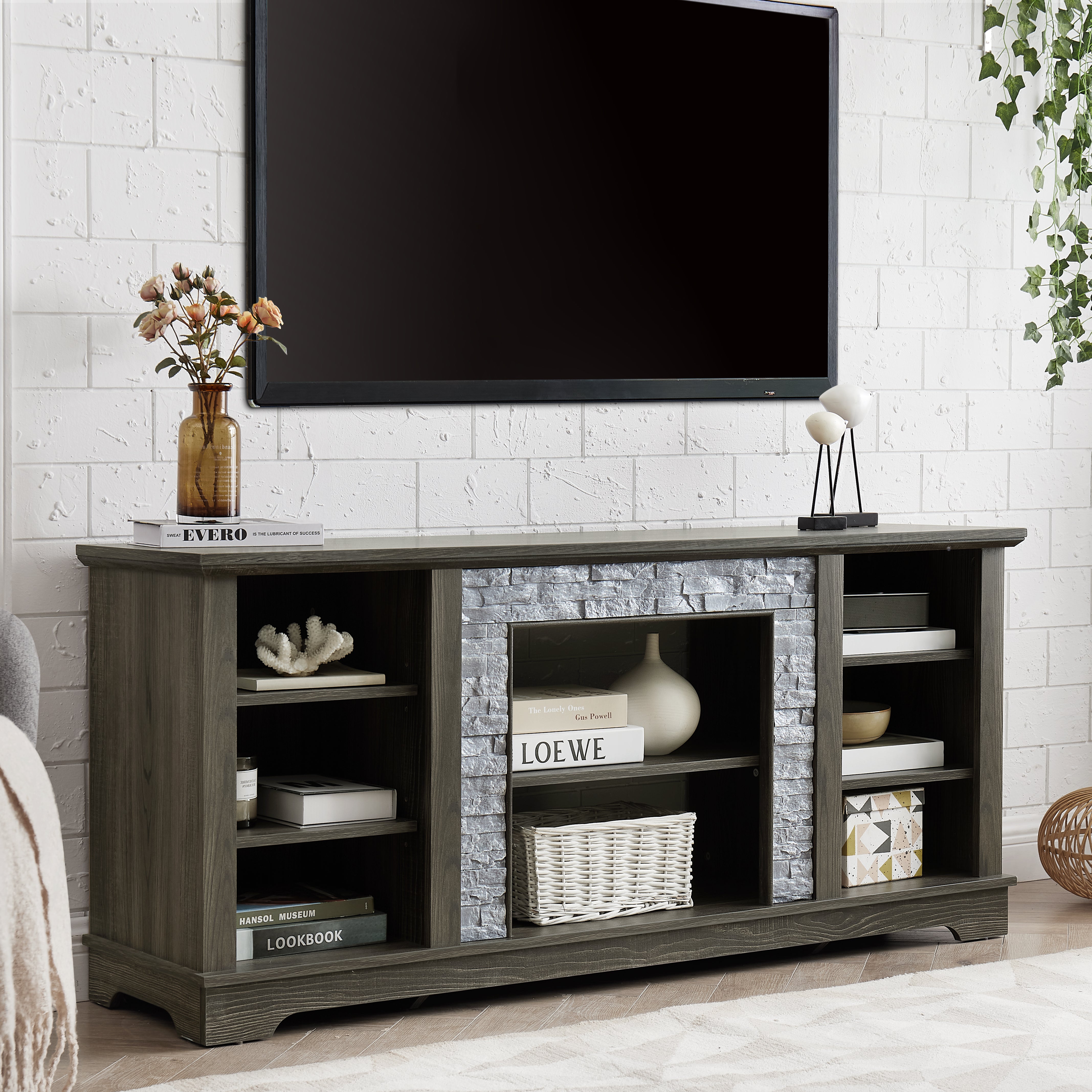 Modern gray stone TV console with open shelves and stacked stone frame