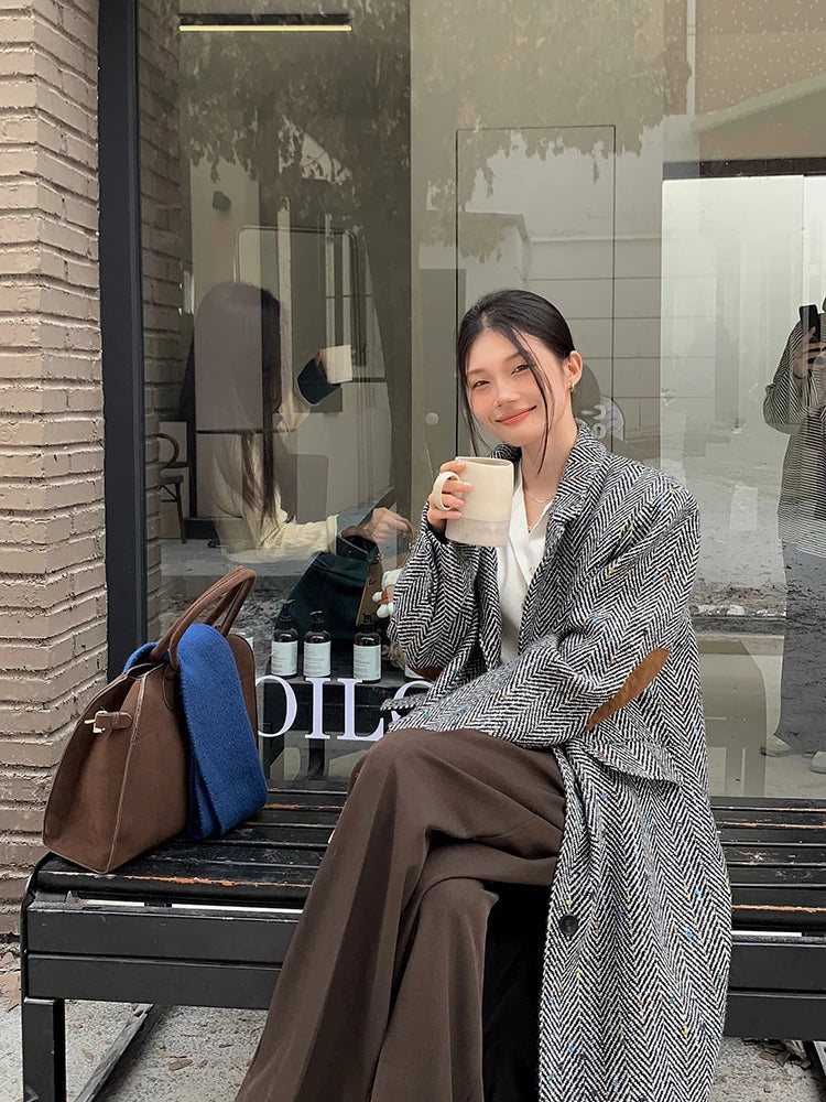 Model wearing a solid plaid minimalist woolen coat in a city street setting