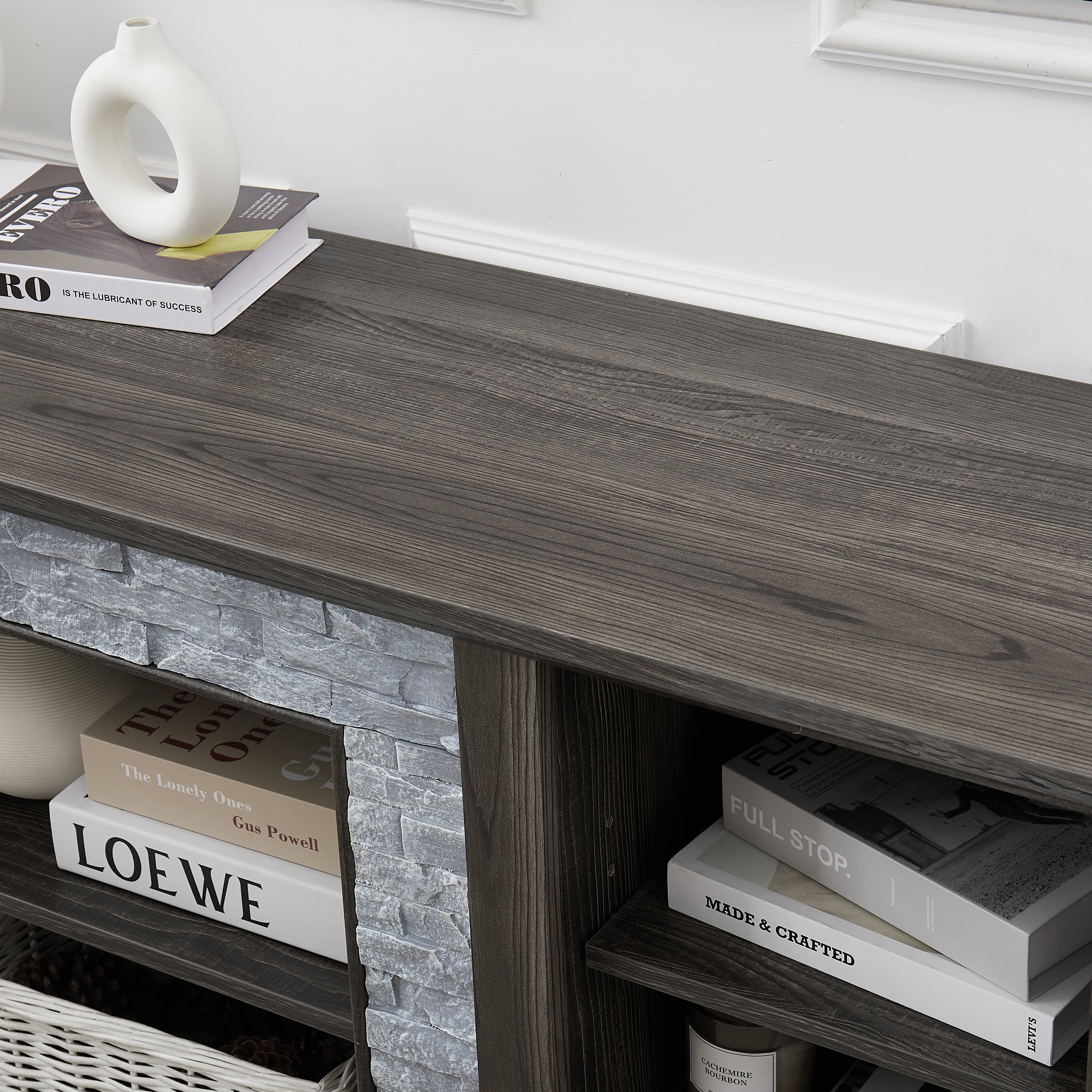 Modern gray stone TV console with open shelves and stacked stone frame