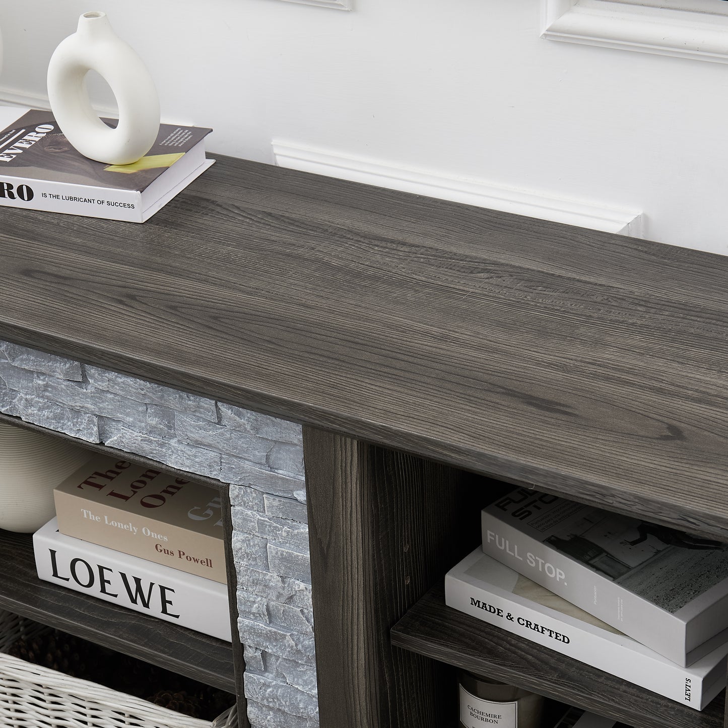 Modern gray stone TV console with open shelves and stacked stone frame