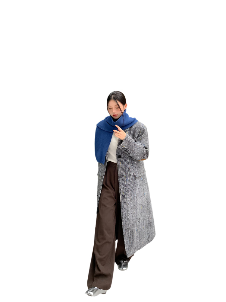 Model wearing a solid plaid minimalist woolen coat in a city street setting