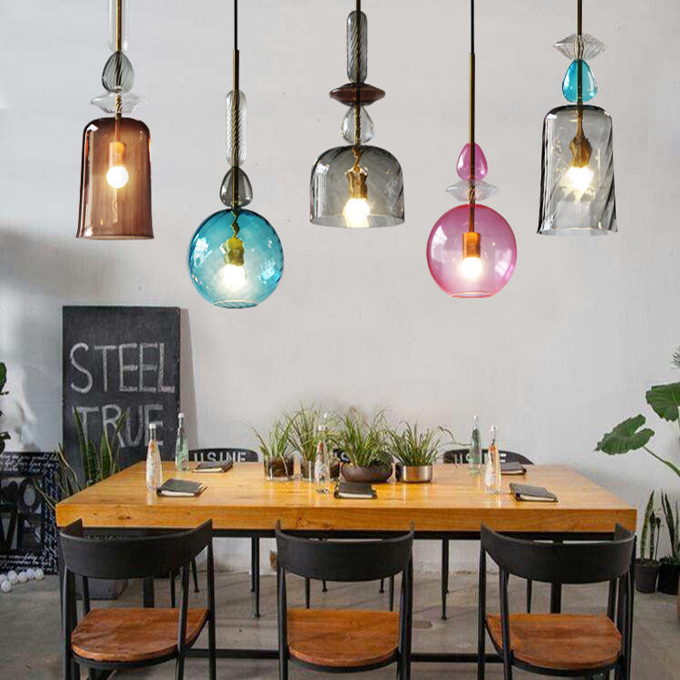 Colorful macaron-style glass chandeliers hanging over a modern bar counter

