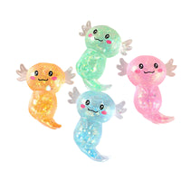 Four colorful, cartoonish axolotl toys on a white plate with a magazine in the background.