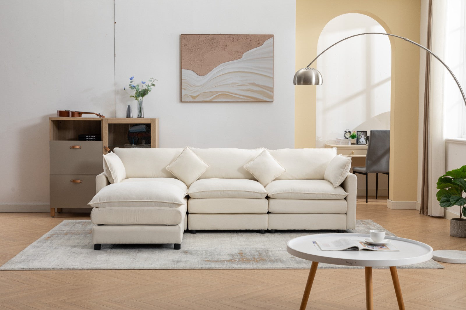 Modern L-shaped 3-seater modular sofa with ottoman in a living room setting.

