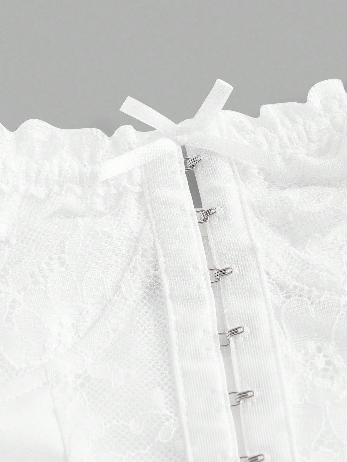 Close-up of a white textured garment with a zipper on a gray background