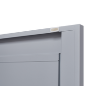 Grey metal kitchen storage cabinet with door and adjustable shelf in a modern kitchen