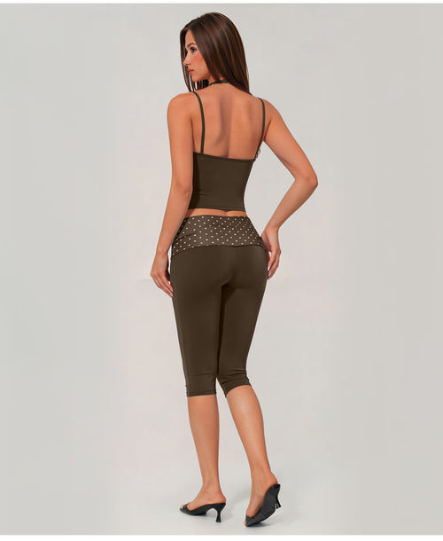 A woman shown from the back wearing an olive green activewear set consisting of a spaghetti-strap crop top and matching high-waisted capri leggings with a sheer mesh waistband.