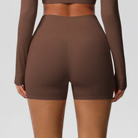 Brown athletic outfit with shorts and long sleeves on a gray background