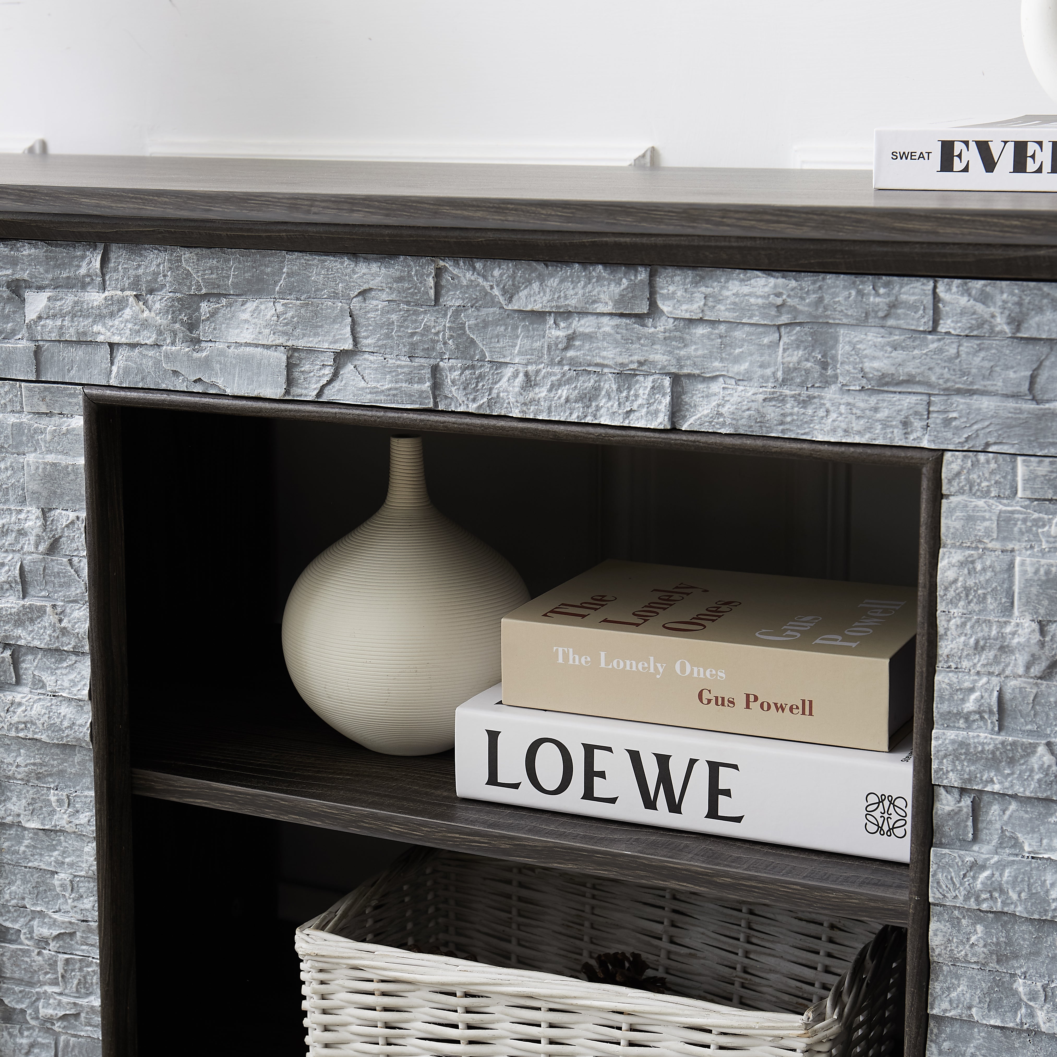 Modern gray stone TV console with open shelves and stacked stone frame