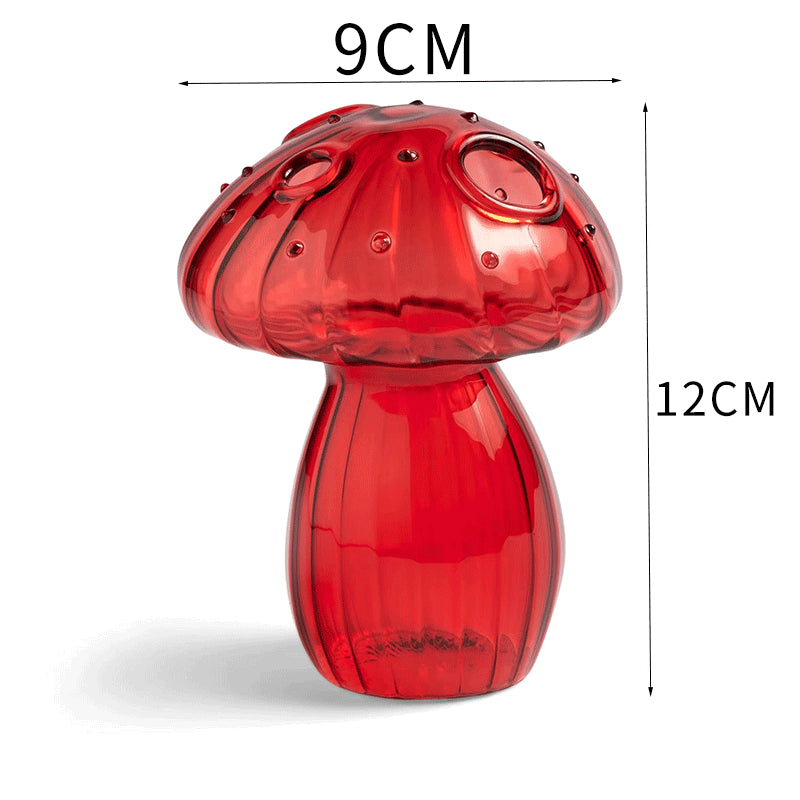 Clear glass mushroom-shaped vase with hydroponic plant and flowers on a minimalist home table


