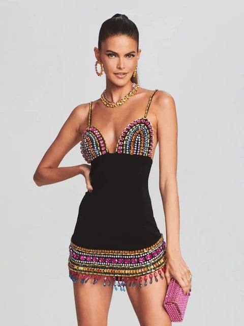 Woman wearing a black sleeveless bodycon dress with colorful crystal embellishments, deep V-neckline, and thin straps—styled for a nightclub or evening party.

