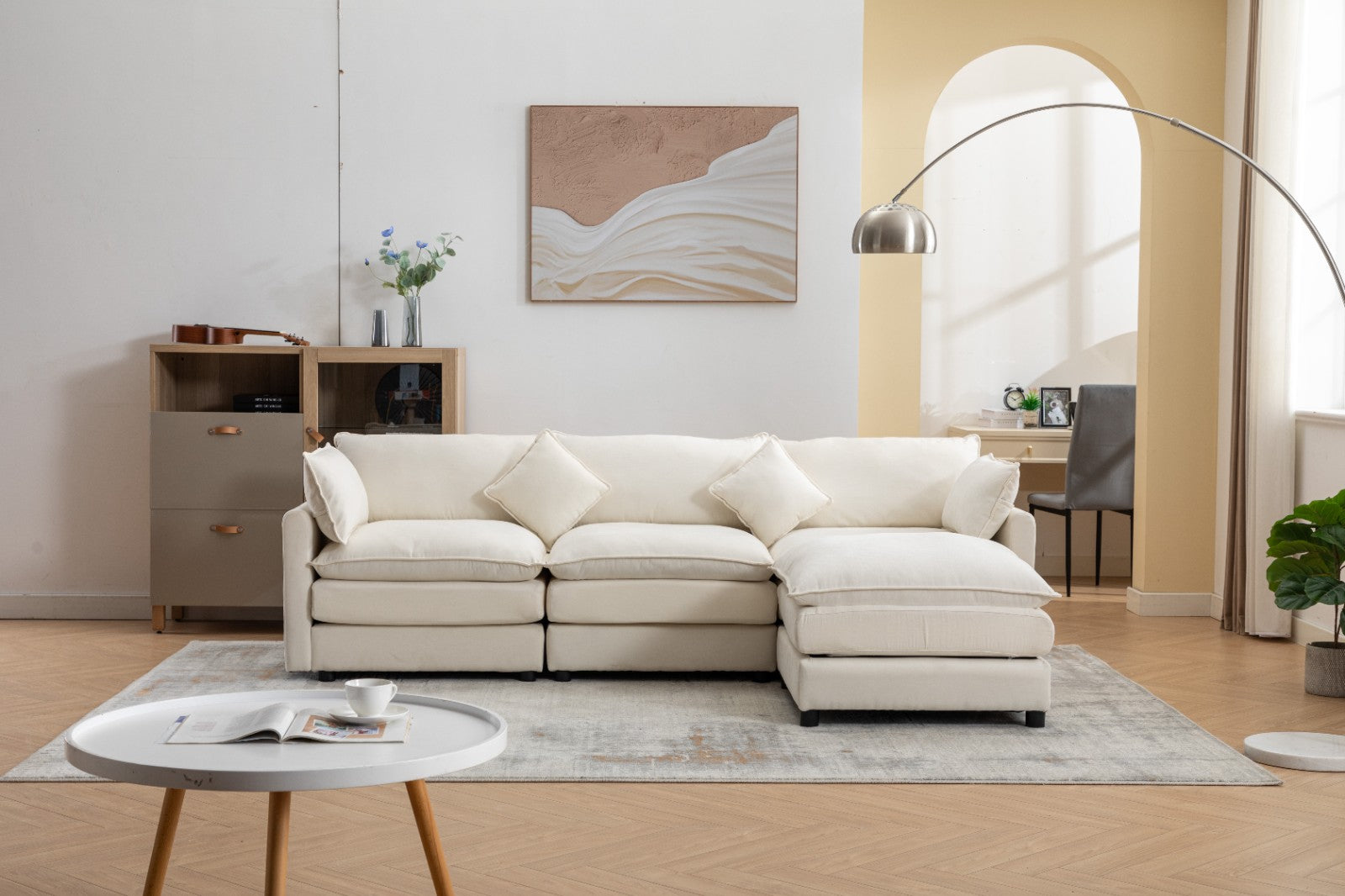 Modern L-shaped 3-seater modular sofa with ottoman in a living room setting.

