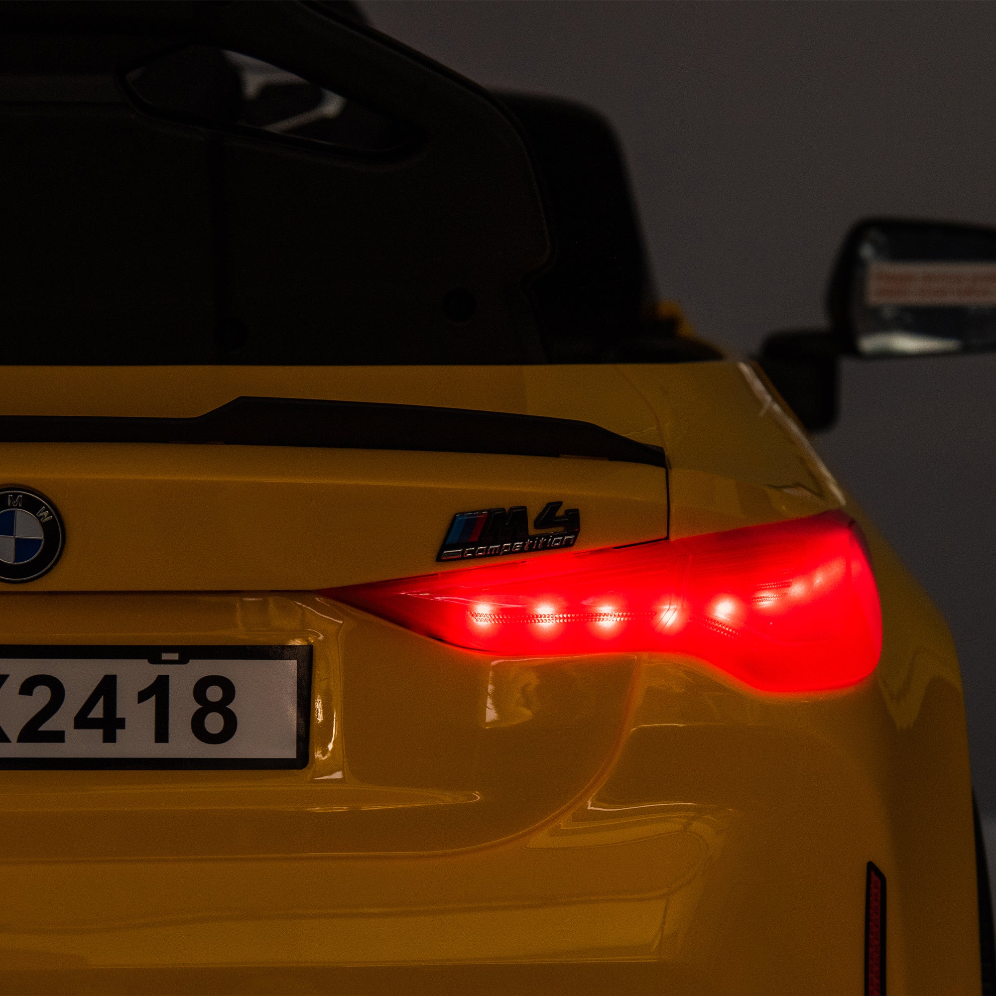 Yellow BMW M4 12V electric ride-on car for kids, featuring authentic design with working headlights, MP3 player, and forward/reverse motion. Comes with adjustable seat and steering wheel, providing a realistic driving experience for children aged 3-6