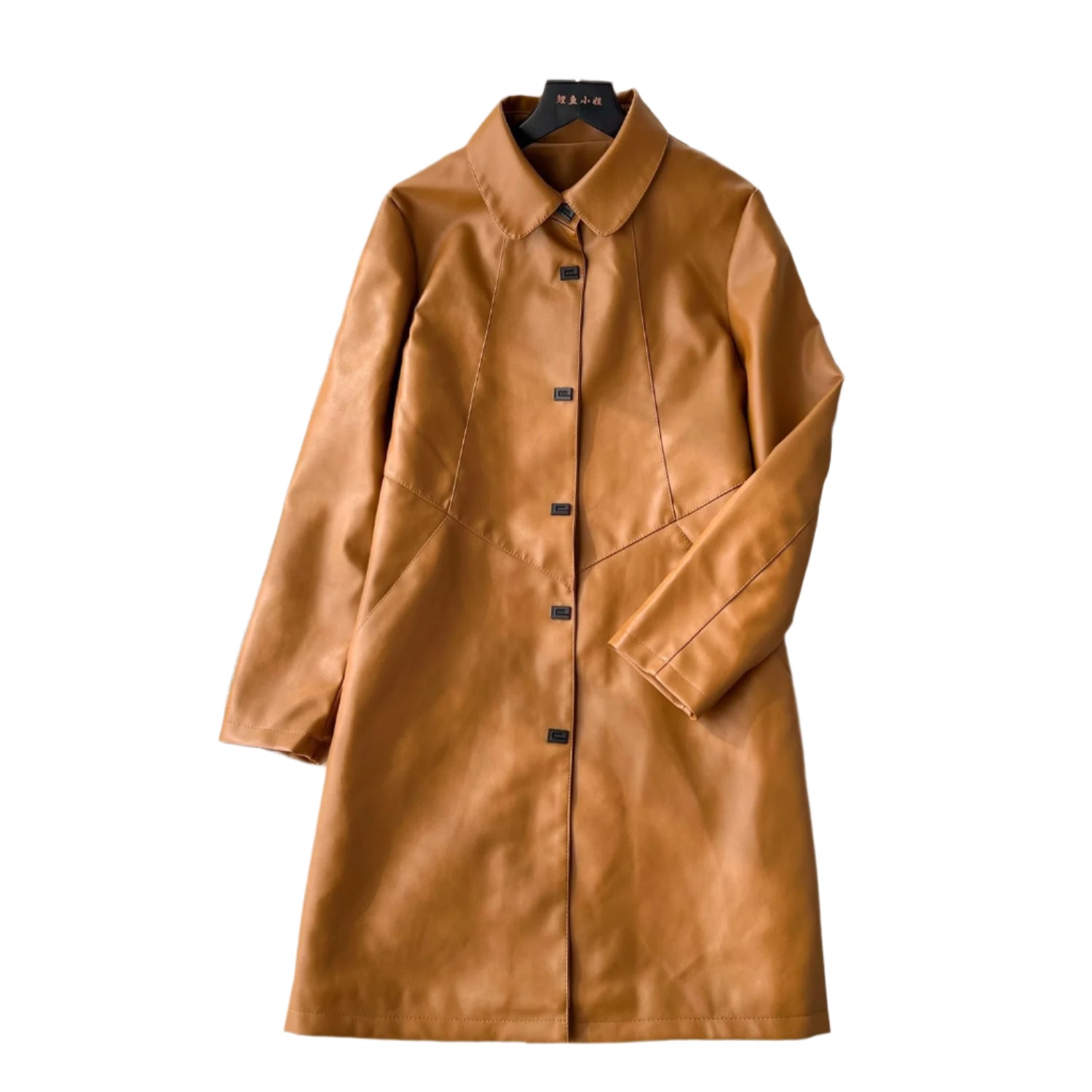 Model wearing a long black PU leather jacket styled with winter boots and a scarf