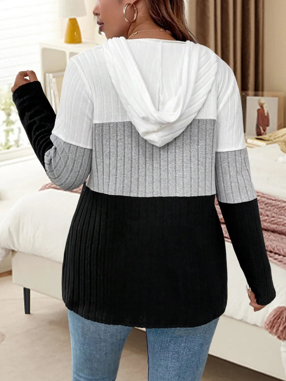 Plus size women's color block knitted hoodie with long sleeves and drawstring hood in cozy knit fabric.








