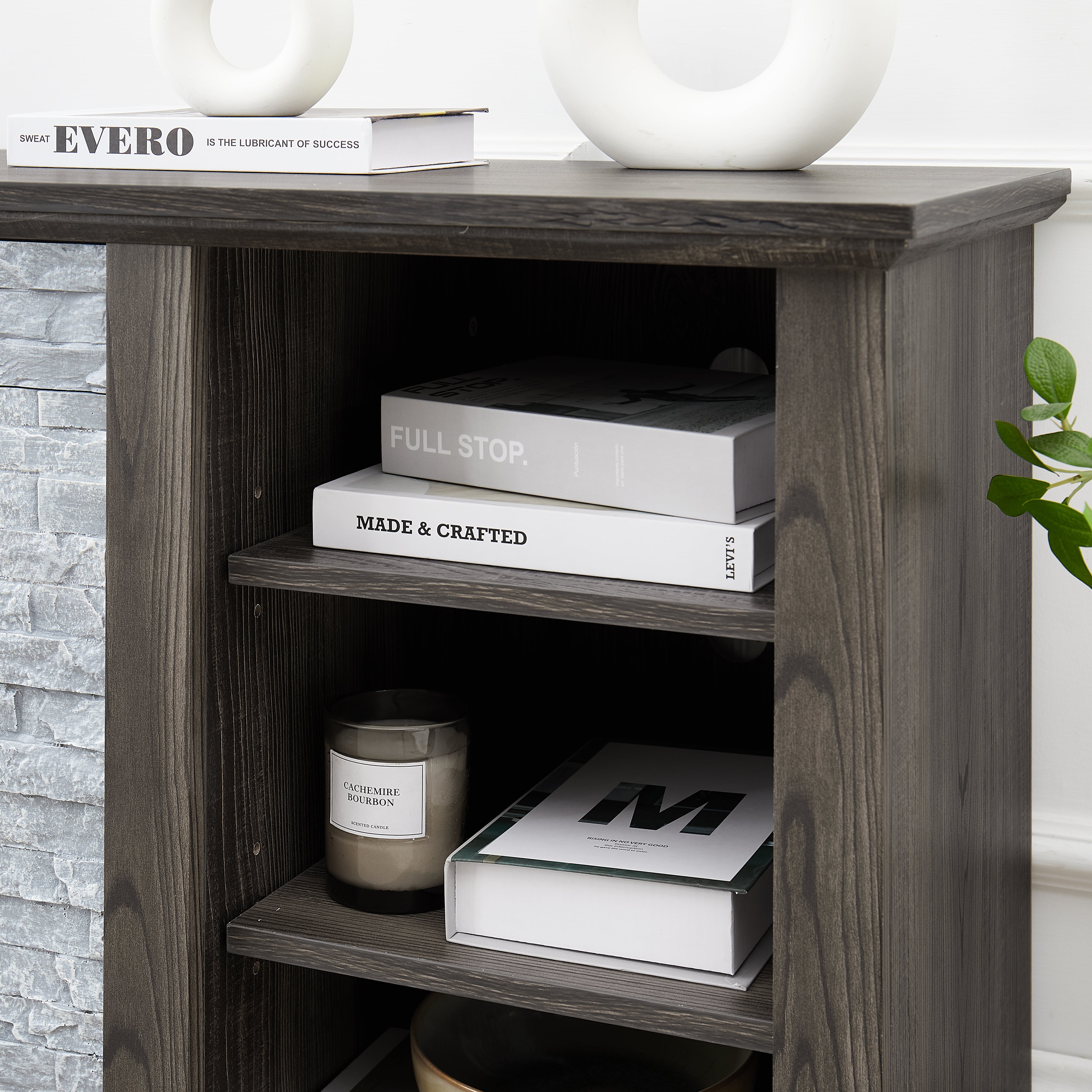 Modern gray stone TV console with open shelves and stacked stone frame