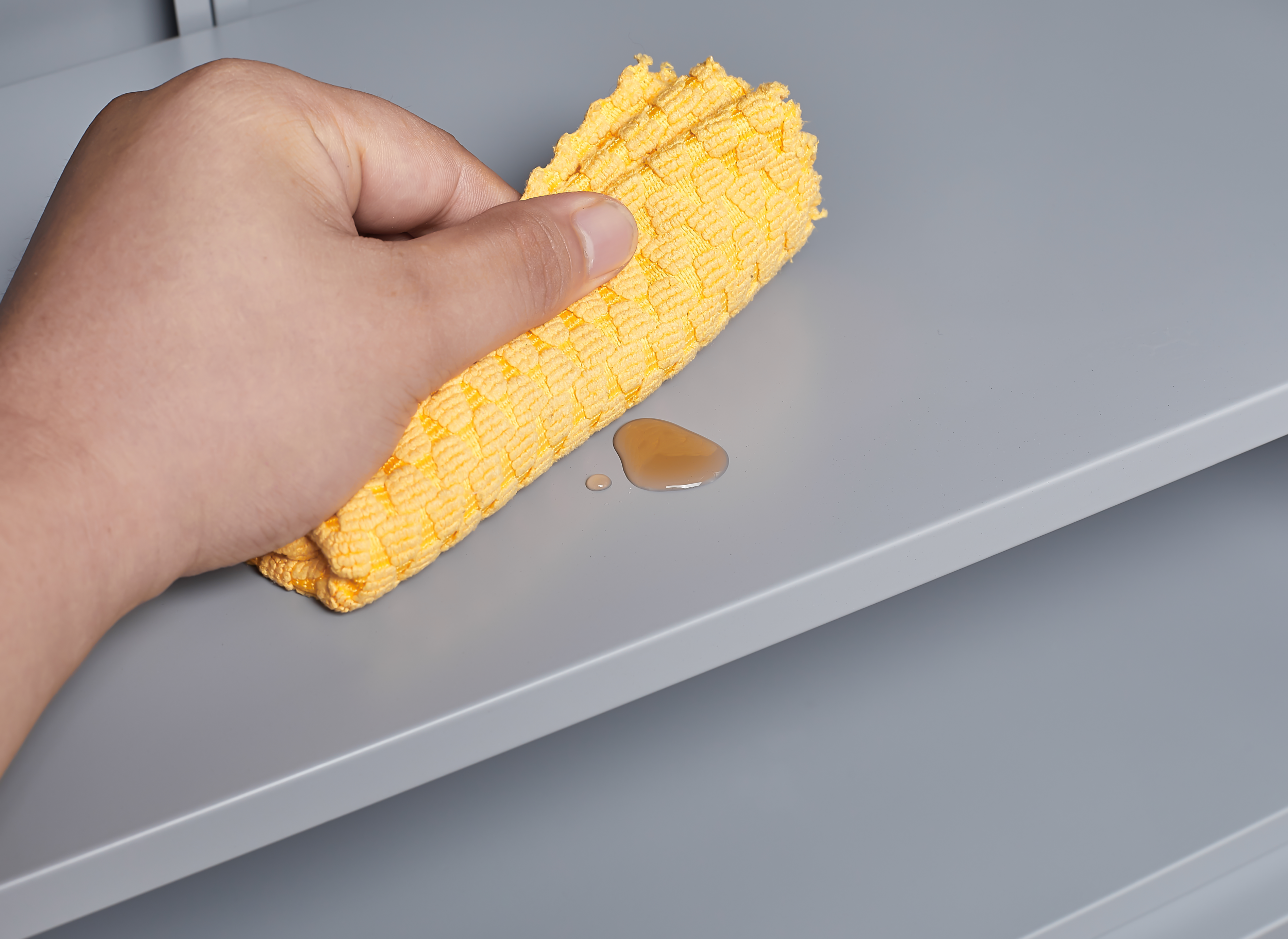 Grey metal kitchen storage cabinet with door and adjustable shelf in a modern kitchen