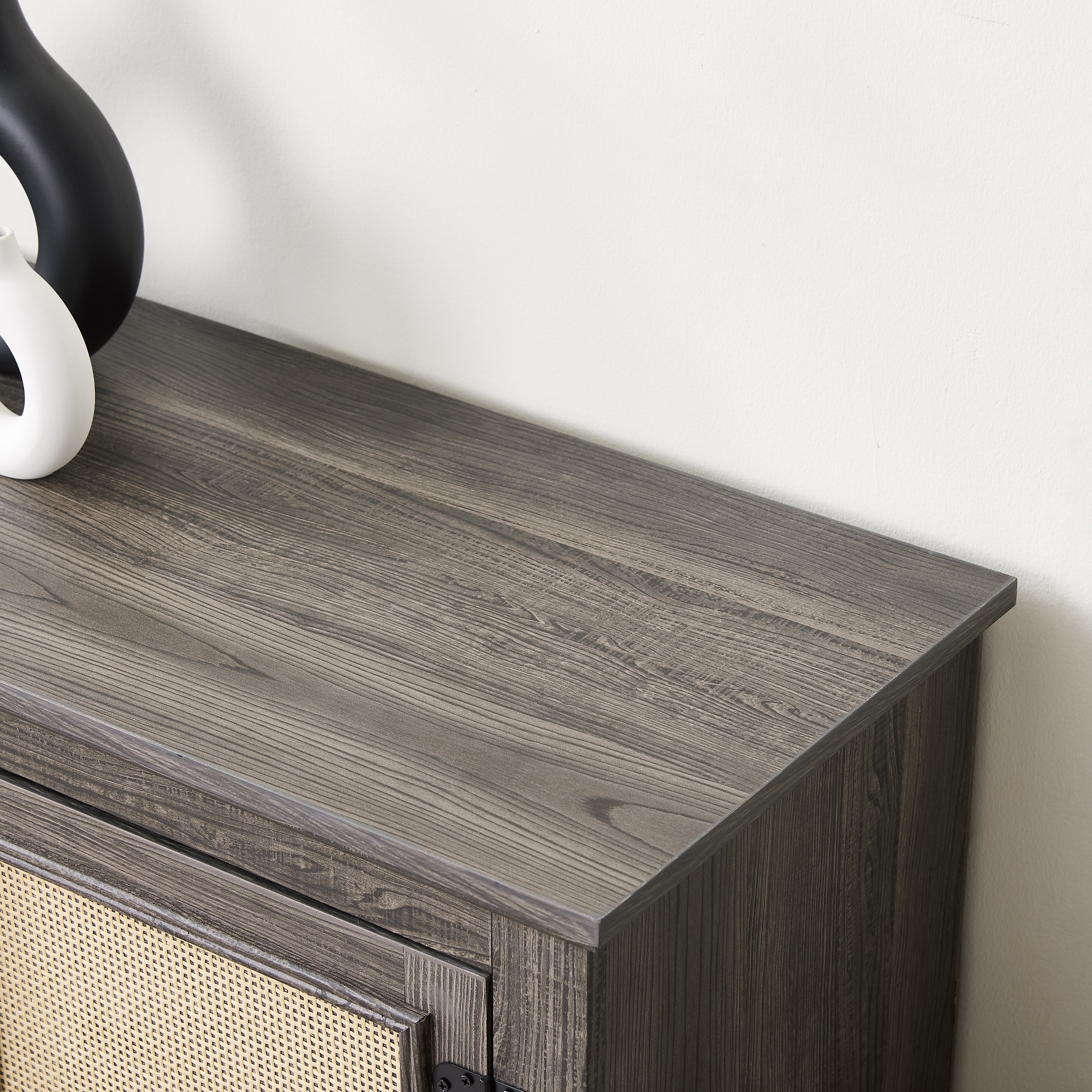 Gray TV stand with rattan doors and shelves for storage
